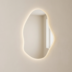 Miroir organique rétroéclairé sur un mur beige sans accessoires, mise en scène générée par IA.